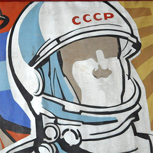 An illustration of a cosmonaut with a white helmet labeled with CCCP in red letters. The figure has no eyes or mouth.
